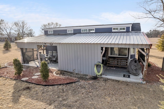 view of front of home featuring metal roof and a patio