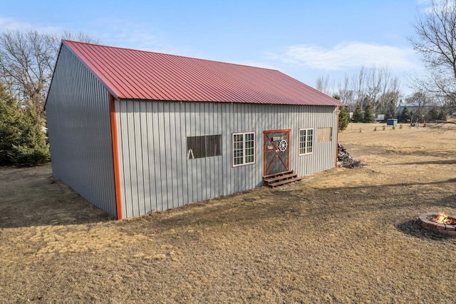 view of outbuilding with an outdoor fire pit and an outdoor structure