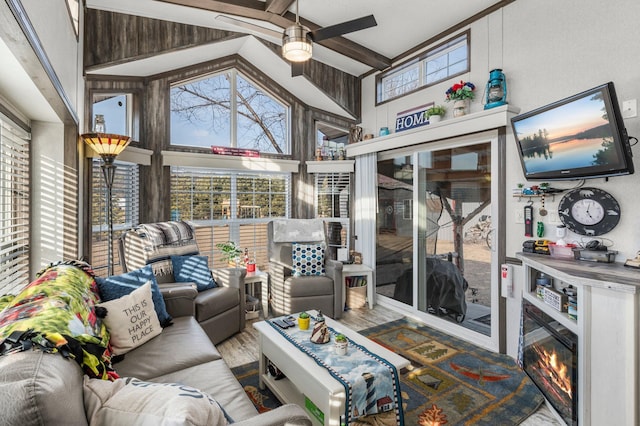 sunroom with lofted ceiling with beams and ceiling fan