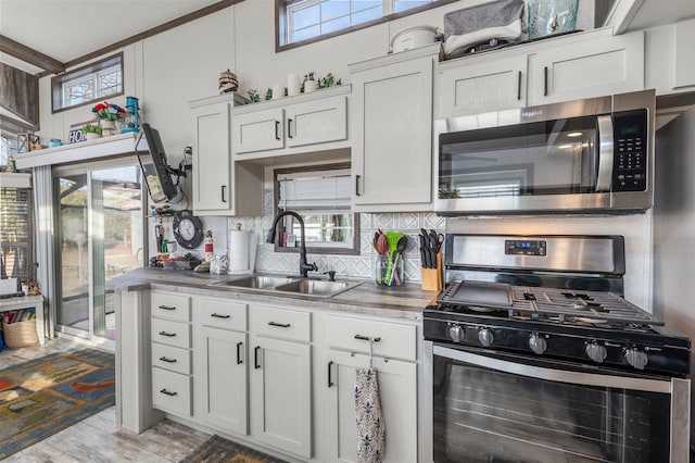 kitchen featuring a sink, tasteful backsplash, appliances with stainless steel finishes, and a healthy amount of sunlight