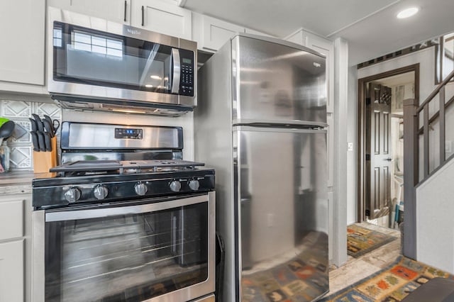 kitchen featuring white cabinetry, decorative backsplash, and stainless steel appliances