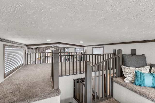 corridor featuring carpet, crown molding, and a textured ceiling