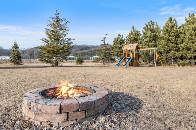 view of jungle gym featuring an outdoor fire pit