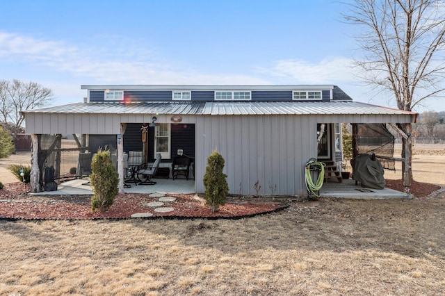 back of property featuring a patio and metal roof