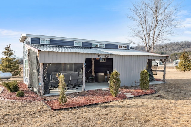 view of front of property with metal roof and a patio area