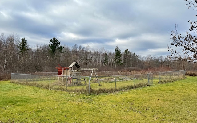 view of yard featuring fence and a wooded view