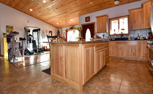 kitchen featuring light tile patterned floors, wood ceiling, a center island, vaulted ceiling, and backsplash