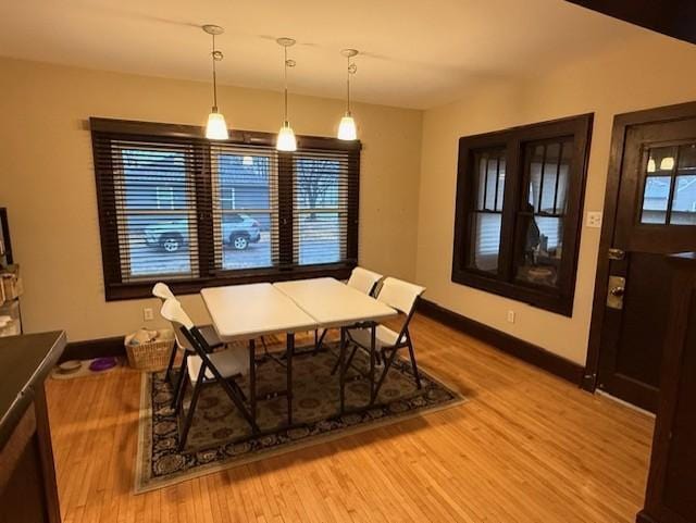 dining space featuring baseboards and light wood-style floors