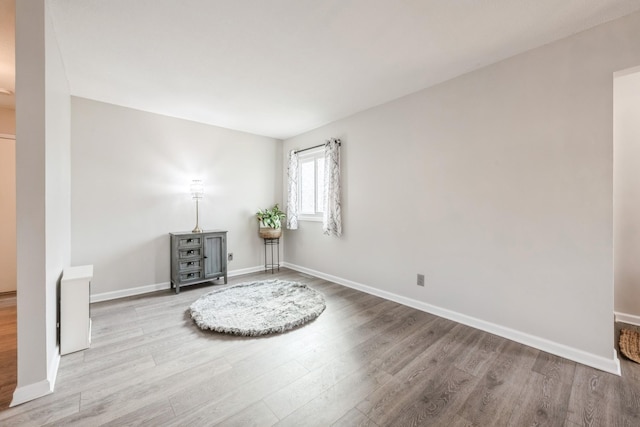 living area featuring baseboards and wood finished floors