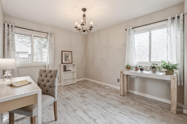 office area with baseboards, plenty of natural light, an inviting chandelier, and wood finished floors