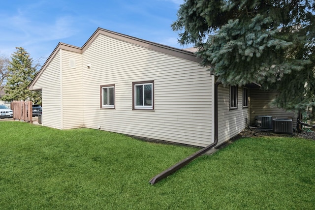 view of home's exterior featuring a lawn and central AC