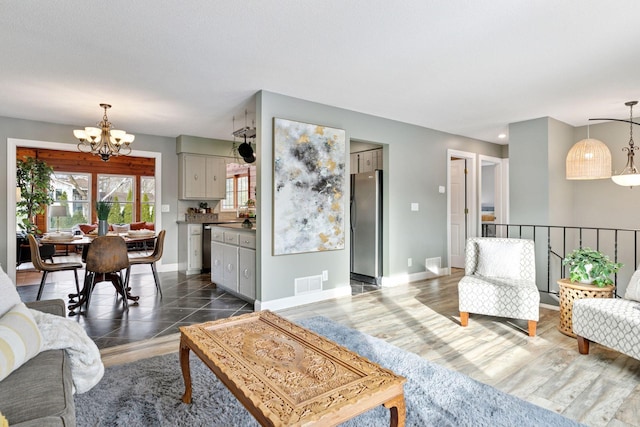 living area with visible vents, baseboards, a notable chandelier, and dark wood-style flooring