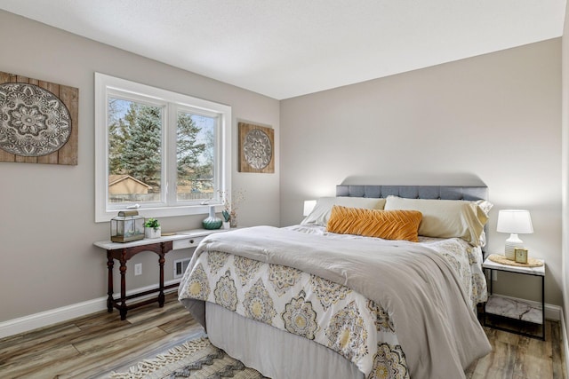 bedroom featuring baseboards and light wood finished floors