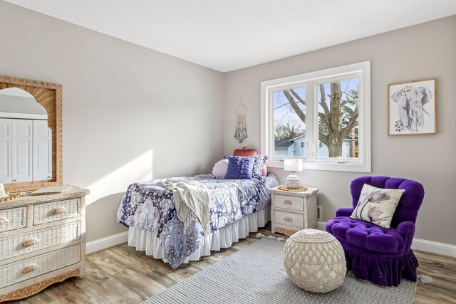 bedroom with baseboards and wood finished floors