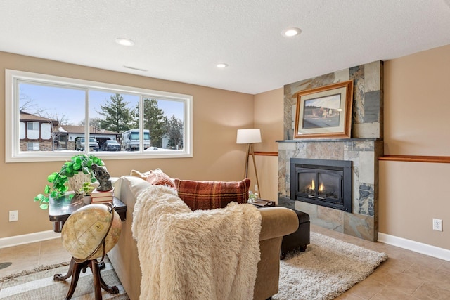 living room with baseboards, a fireplace, and tile patterned flooring