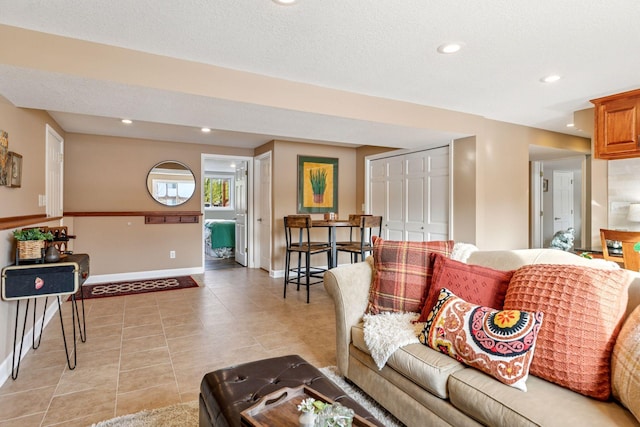 living area featuring recessed lighting, baseboards, a textured ceiling, and light tile patterned floors