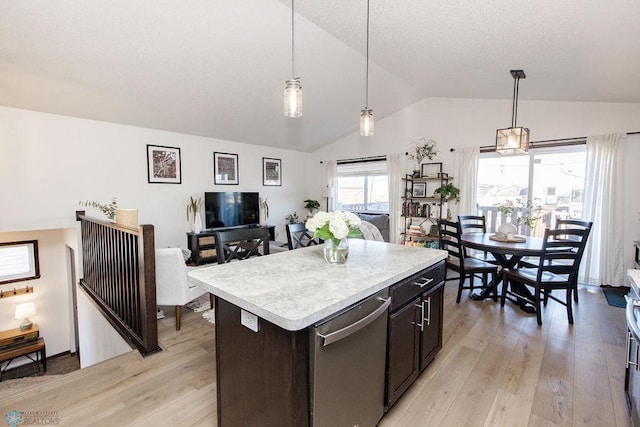 kitchen featuring lofted ceiling, light countertops, hanging light fixtures, and light wood-style floors