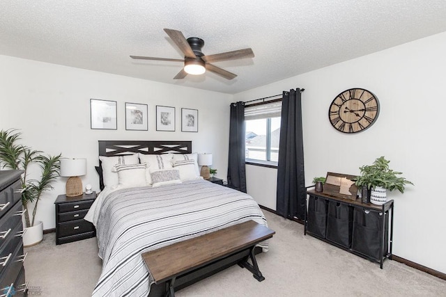 bedroom featuring light carpet, baseboards, and a textured ceiling