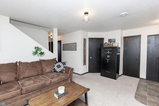 living room featuring light carpet, baseboards, and a textured ceiling