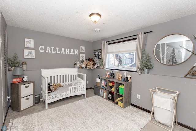 bedroom with carpet floors, a textured ceiling, baseboards, and a crib