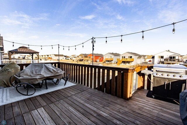 wooden terrace featuring a residential view and a gazebo