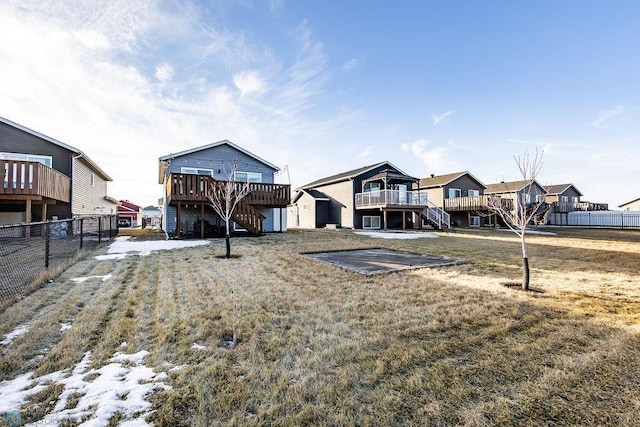 view of yard with a deck, stairway, fence, and a residential view