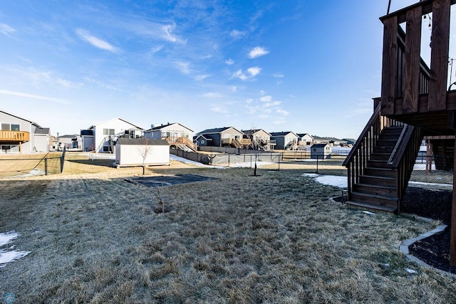 view of yard with stairway, fence, and a residential view