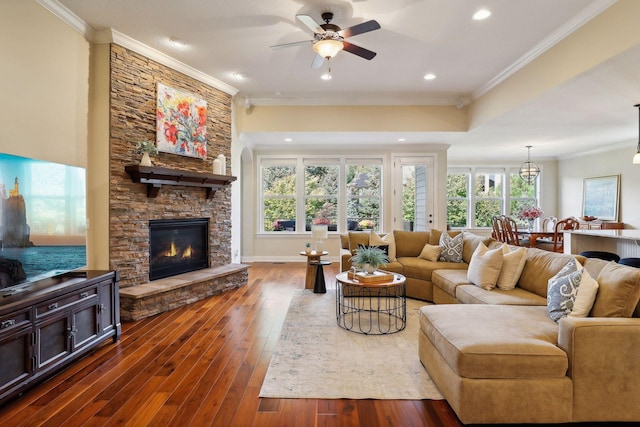 living area featuring a healthy amount of sunlight, dark wood finished floors, and crown molding