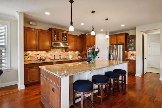 kitchen featuring stainless steel appliances, a sink, range hood, dark wood-style floors, and brown cabinetry