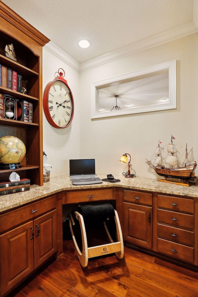 home office with dark wood finished floors, crown molding, built in desk, and a textured ceiling