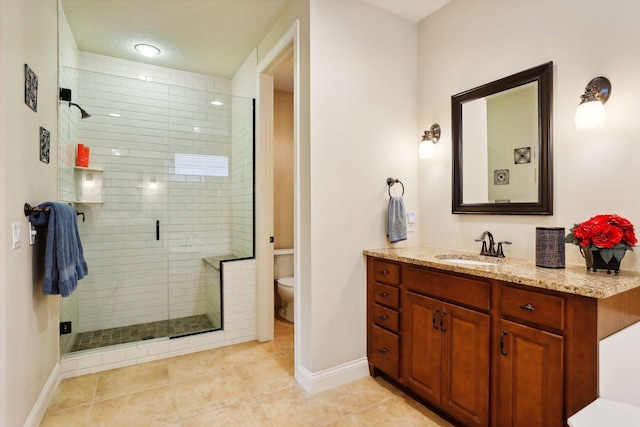 full bath featuring a textured ceiling, toilet, vanity, baseboards, and a stall shower