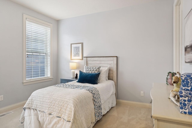 bedroom with baseboards, multiple windows, visible vents, and light colored carpet