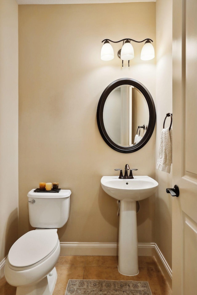 bathroom with toilet, tile patterned flooring, and baseboards