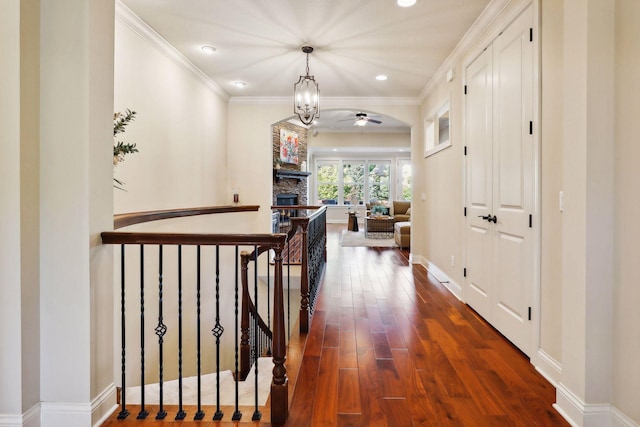 hallway with recessed lighting, dark wood-type flooring, an upstairs landing, baseboards, and ornamental molding