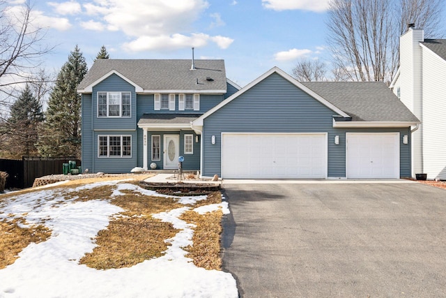 view of front of property with driveway, a shingled roof, an attached garage, and fence