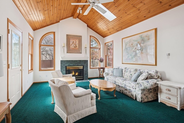 living area with carpet flooring, a glass covered fireplace, plenty of natural light, and wood ceiling