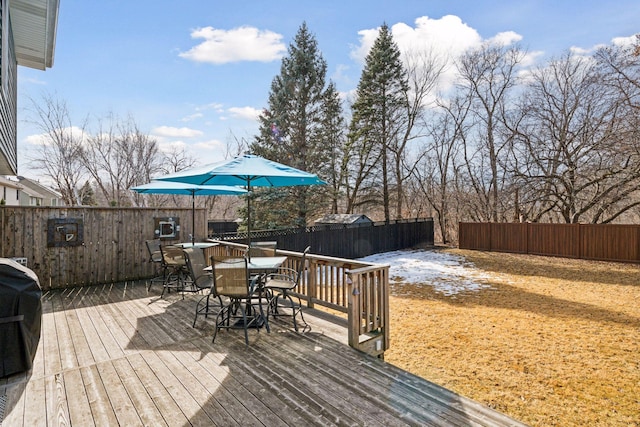 wooden deck featuring outdoor dining area and a fenced backyard