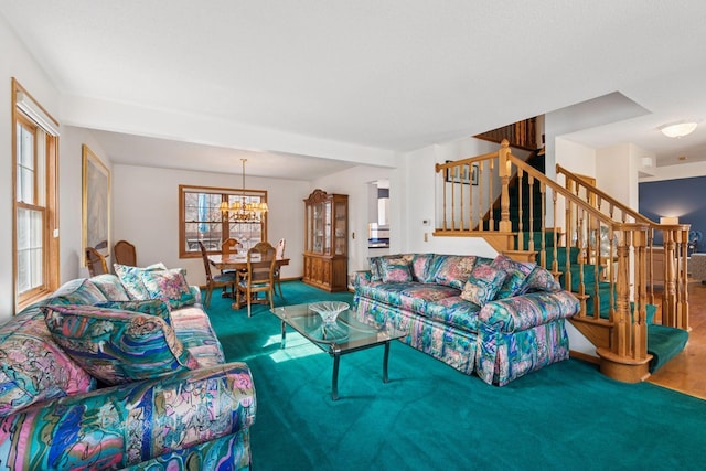 living area featuring stairs, carpet flooring, and a chandelier