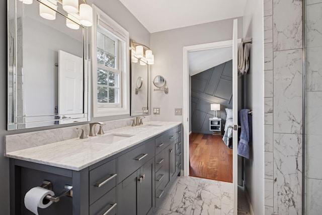 full bathroom with double vanity, marble finish floor, and a sink