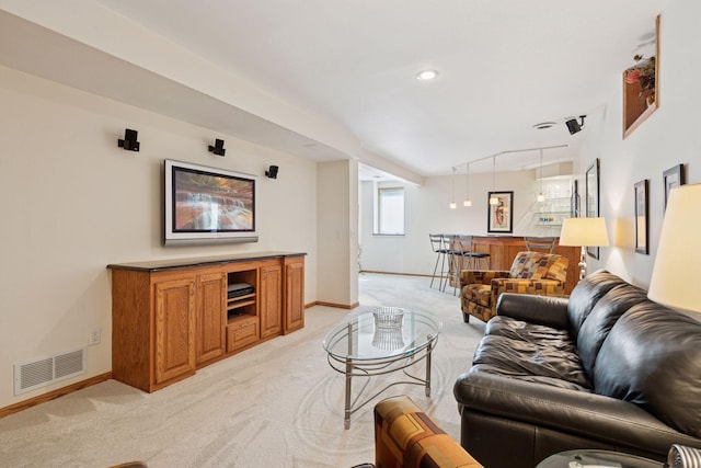 living area with light carpet, visible vents, and baseboards