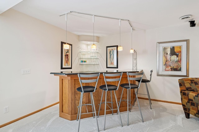 bar featuring decorative light fixtures, carpet flooring, bar area, and baseboards