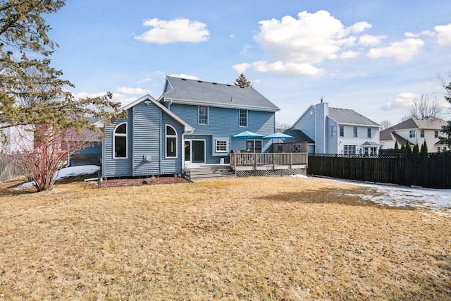 back of house featuring a wooden deck, a yard, and fence