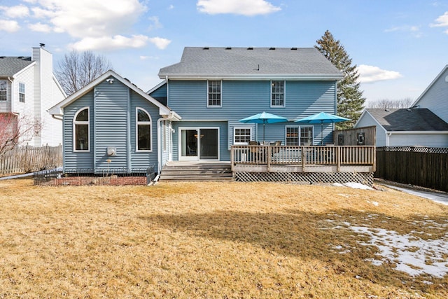 back of house with a deck, fence, and a lawn