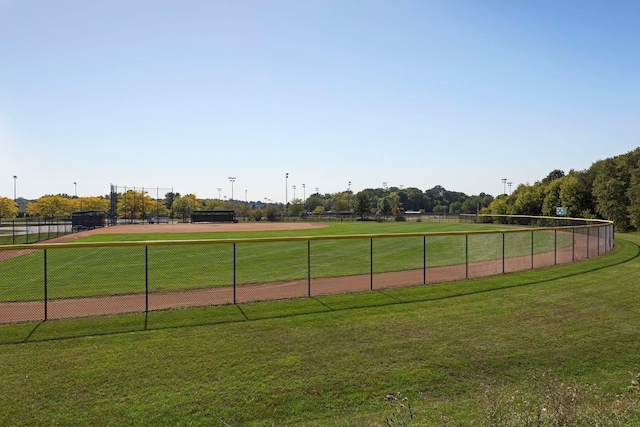 view of sport court with a yard and fence