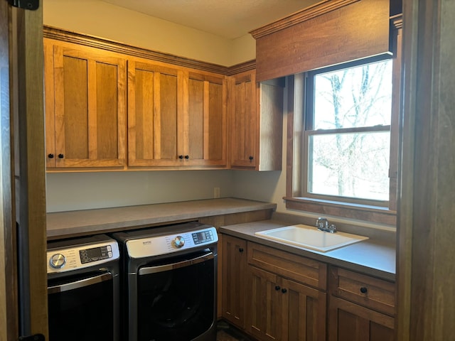 laundry room featuring cabinet space, independent washer and dryer, and a sink