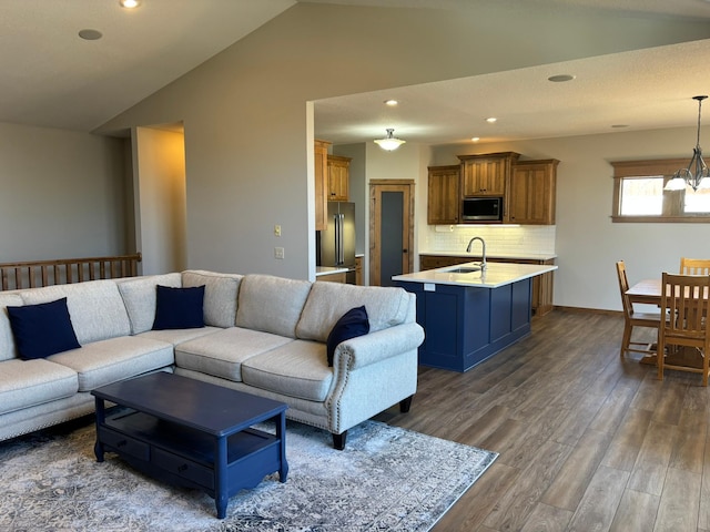 living room featuring recessed lighting, vaulted ceiling, dark wood finished floors, and an inviting chandelier