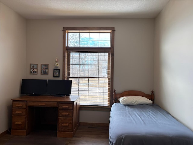 bedroom featuring multiple windows and wood finished floors