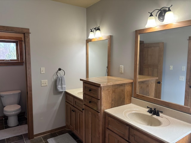 bathroom featuring baseboards, vanity, toilet, and tile patterned floors