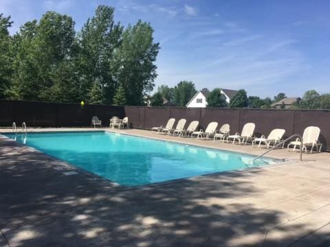 community pool with a patio and fence