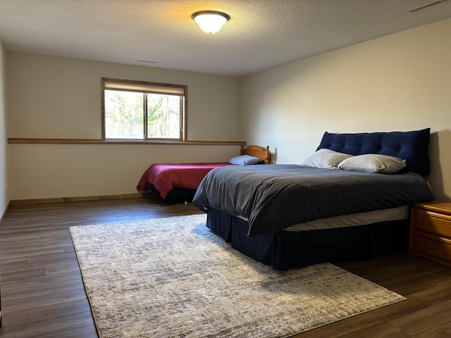 bedroom with dark wood finished floors and a textured ceiling